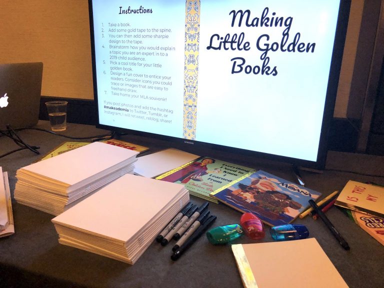 Screen reads Making Little Golden Books behind a table filled with Little Golden Books, blank books, and Sharpie pens